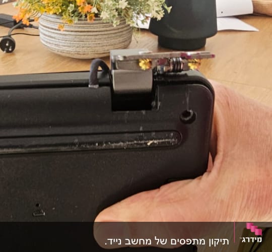 חלק תחתון של מחשב נייד עם חיבור שבור